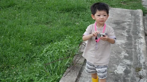 Slow motion scene, cute boy holding small compact camera take a photo Stock Footage 113402133