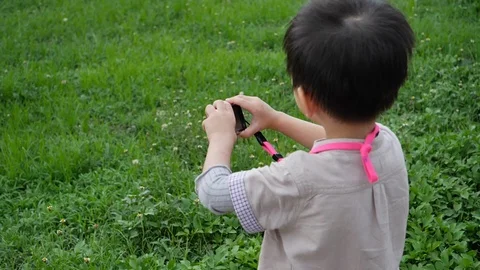 Slow motion scene, cute boy holding small compact camera take a photo Stock Footage 113402340