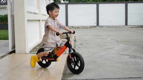 Slow motion scene, cute boy playing balance bike on street Video stock 113403022