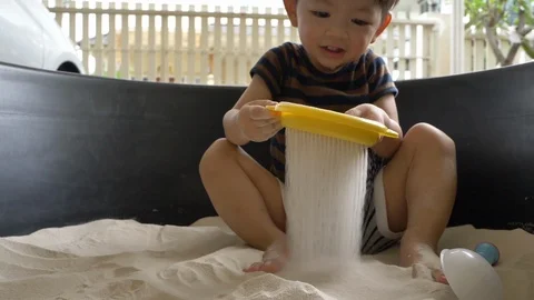 Slow motion scene, cute child playing sand in playground Stock Footage 99128218
