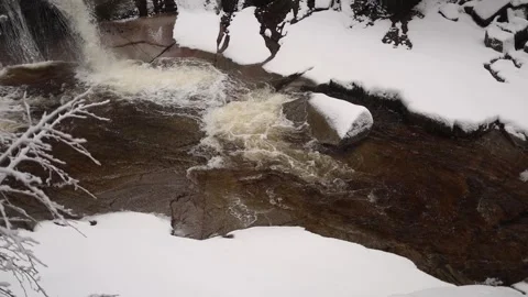 In a slow-motion scene, a river cascades over rocks, forming swirling currents b Stock Footage 300021309