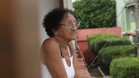 Slow motion scene of thoughtful elderly Brazilian woman on her home quarantine Stock Footage 130348521