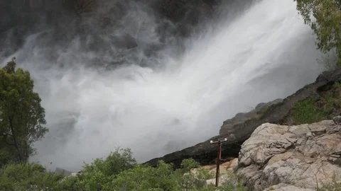 Slow motion scene of waterfall splashing water vapor into rocky cliff 스톡 동영상 118997346