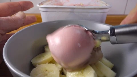 Slow motion - Scooping ice cream into bowl with banana (1). Stock Footage 107880180
