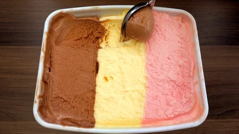 Slow motion – Scooping Neapolitan ice cream in a tub. Vídeos de archivo 107386285