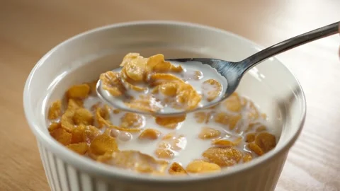 Slow motion scooping spoon cornflakes cereal with spoon from bowl full of milk Stock Footage 294696674