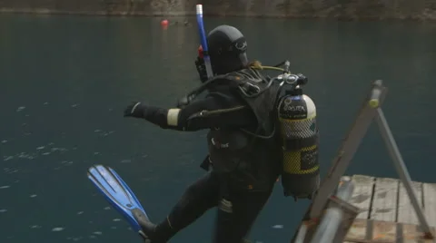 Slow Motion Scuba Diver jumps off jetty and ends up upside down Stock Footage 48587379