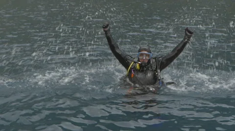 Slow Motion Scuba Diver raises arms in celebration Stock Footage 48587171