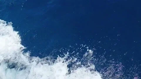 Slow motion sea foam and splash from moving yacht hull in deep blue ocean Stock Footage 341362376