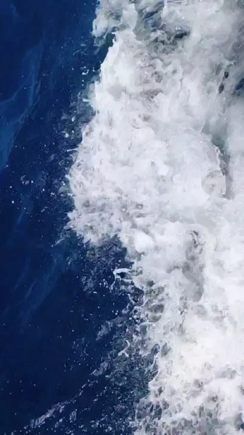 Slow motion sea foam and splash wave from moving yacht boat in deep blue ocean Stock Footage 341362745
