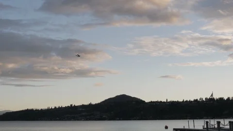 Slow Motion Sea Plane Flying Over Lake and Mountains at Sunset Stock Footage 92210973
