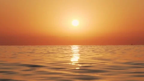 Slow motion of the sea surface with small waves against the sunrise of the sun Video stock 100088588