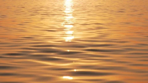 Slow motion of the sea surface with small waves against the sunrise of the sun Stock Footage 100088710
