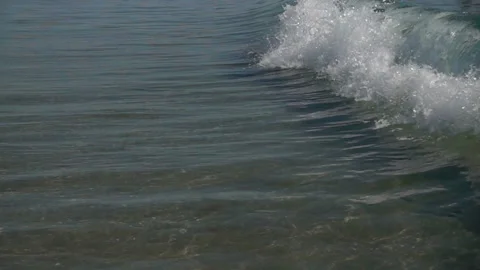 Slow motion sea wave with splashes rolls on shore. Stock Footage 112936139