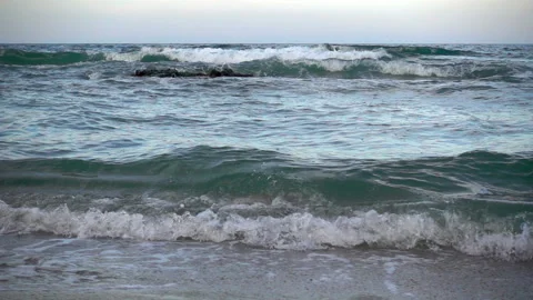 Slow motion of sea waves passes through a small stone reef Stock Footage 93597952
