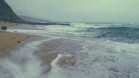Slow motion: Sea waves rolling on a sandy beach in cloudy rainy weather. Came Stock Footage 219945699