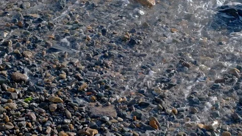 Slow motion sea waves with white foam washing up pebble stones on the beach Stock Footage 121532780