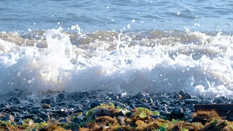 Slow motion sea waves with white foam washing up pebble stones on the beach Stock Footage 121533435