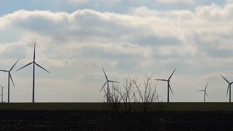 Slow motion seamless loop medium shot white two wind turbines blue sky clouds Stock Footage 101544649