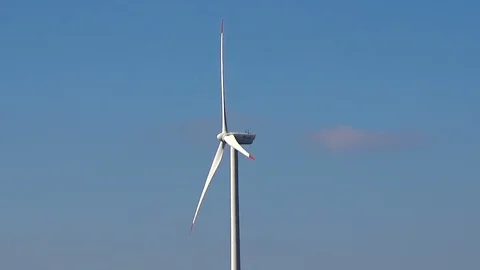 Slow motion seamless loop middle shot white wind turbine blue sky clouds clean Stock Footage 101543101