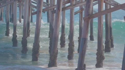 Slow motion seaside pastels of waves crashing under Balboa Pier Newport Beach Stock Footage 174894122