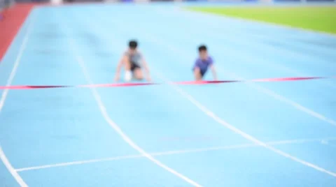 Slow motion selective focus at young Asian boy running on blue track to the fini Stock Footage 67191078