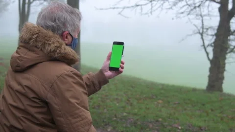 Slow Motion Senior Man Talking Video Call in Park Stock Footage 152412405