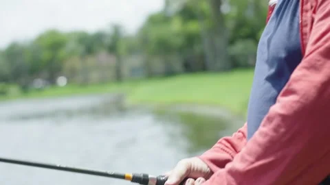 Slow motion of senior man's hands as he fishes on a lake Stock Footage 131058792