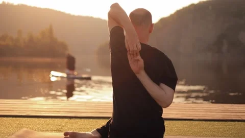 Slow motion of a serious young man meditating on the river bank Stock Footage 246559380
