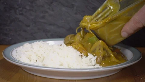 Slow motion - Serving Chinese takeout vegetable curry with boiled rice on plate. Stock-Footage 105678993