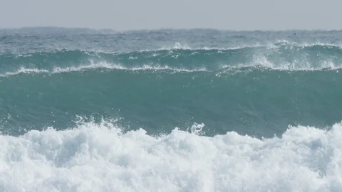 Slow motion of a set huge waves breaking roughly Stock Footage 106216921