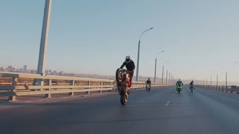 Slow motion. Several motorcyclists perform stunts on the empty highway. Stunt Stock Footage 105011403