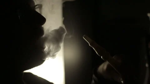 SLOW MOTION: Shadow of a man smoking a hookah. Stock Footage 47245667