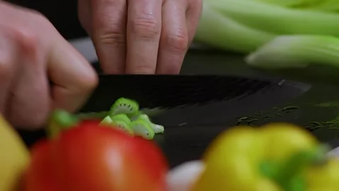 In slow motion, a sharp knife cuts celery; The man's strong hands hold a sharp 库存影片 273013097