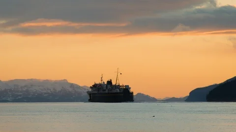 Slow motion of ship floating across sea towards mountains on sunset, Alaska Stock Footage 129108094
