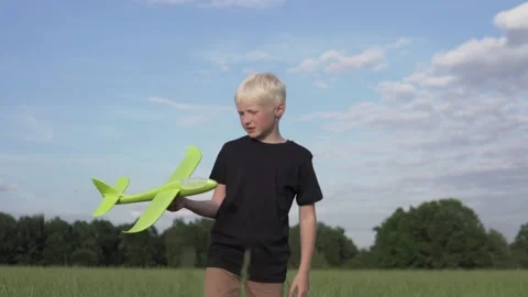 Slow-motion shooting boy blond launches a toy plane Stock Footage 136719453