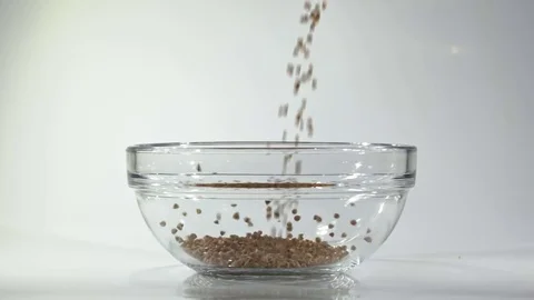 Slow-motion shooting of buckwheat strewing in a bowl. Stock-Footage 80676932