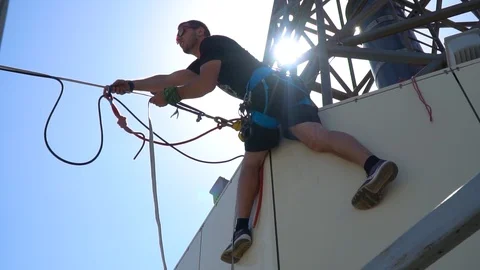 Slow-motion shooting, like a man hanging on the roof of a building and pulling Stock Footage 89832408