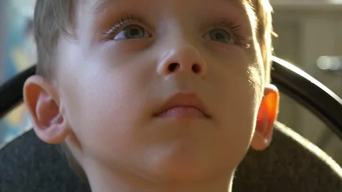 Slow-motion shooting of a pensive child's face close-up. The child looks Stock Footage