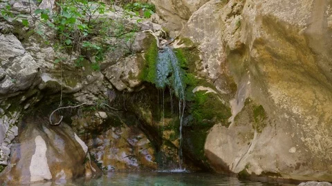 Slow-motion shooting of a small mountain waterfall Stock Footage 90614255