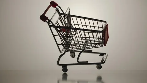 SLOW MOTION: Shopping cart falling down and turning over on the white surface Stock Footage 101621977