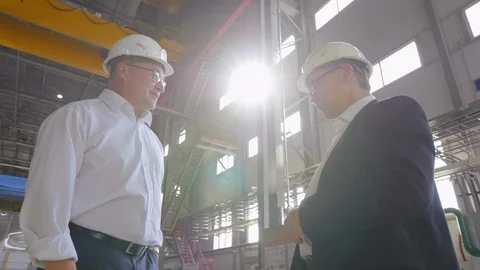 Slow motion shot of asian and caucasian engineers or businessmen shake hands in Stock Footage