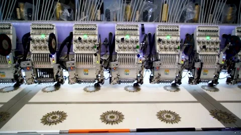 Slow motion shot of automatic embroidery machine with multiple heads in text Stock Footage 199272402