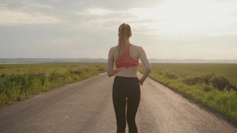 Slow motion shot back runner woman running in road field sunset outdoors fitness Stock Footage 112745384