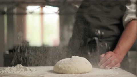 Slow motion shot: Baker pours flour on dough for bread. Baker sprinkles pinch of Vídeo Stock 139152195