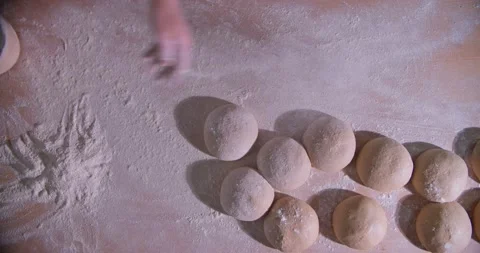 Slow Motion shot of bakery chef applying and sprinkles flour over bread dough Stock Footage 156335480