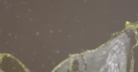 Slow motion shot of a balloon filled with yellow water popping and releasing Stock Footage 311915523