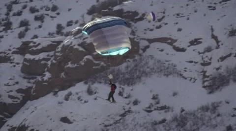 Slow-motion shot of base jumper flying through the air with open chute. Stock Footage 52226269