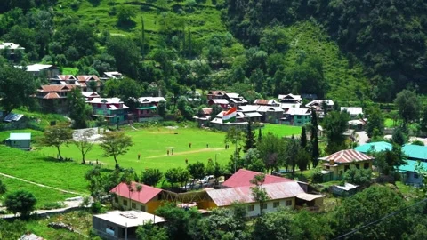 Slow motion shot of beautiful huts and cricket stadium with lush green mount Stock Footage 200744205