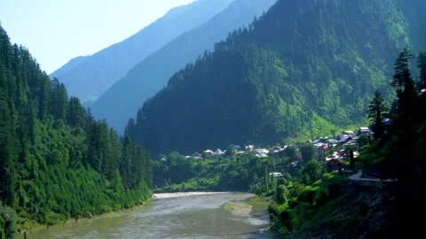 Slow motion shot of beautiful huts with lush green mountains and river in hi Stock Footage 200744209